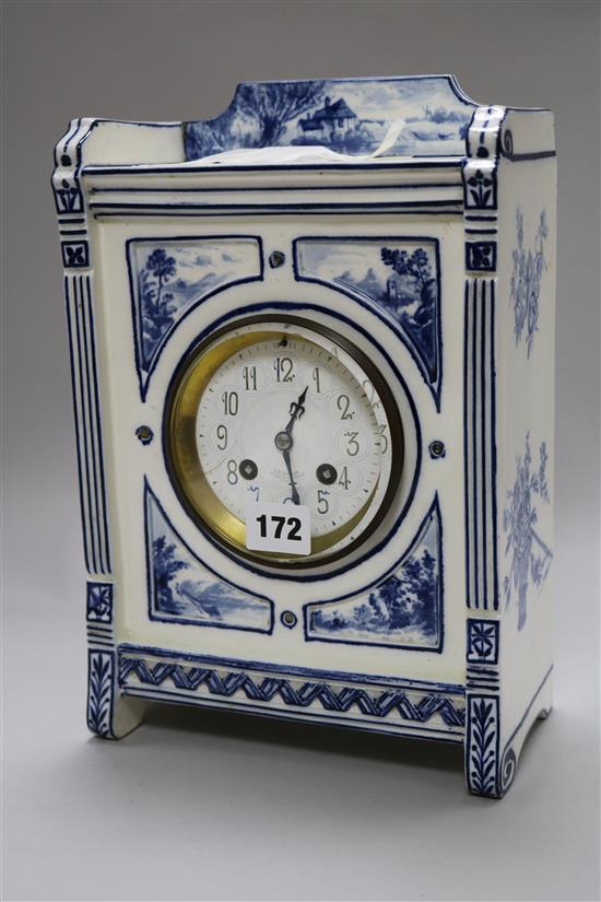 An Edwardian blue and white pottery mantel clock, with dial signed J.W. Benson, 29cm